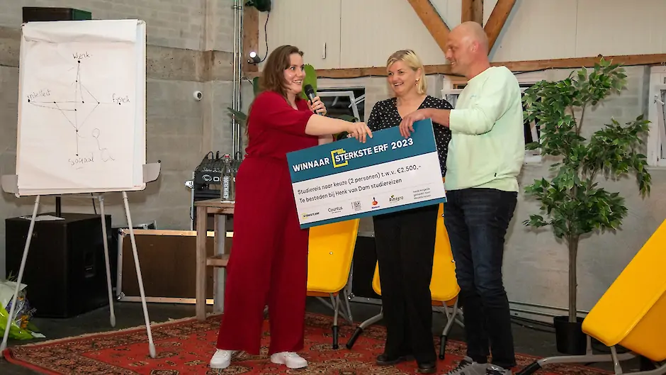 Amber Laan reikt de prijs uit aan familie Ten Kate, winnaar van De Sterkste Erf Verkiezing